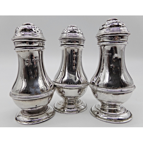 256 - Three Edwardian silver baluster peppers, engraved with a dog head crest, maker George Perkins, Londo... 