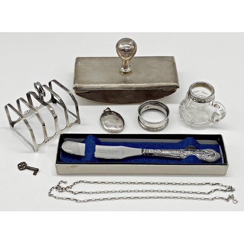 235 - Mixed collection of silver to include blotter, toast rack, butter knife, napkin ring, chain link nec... 