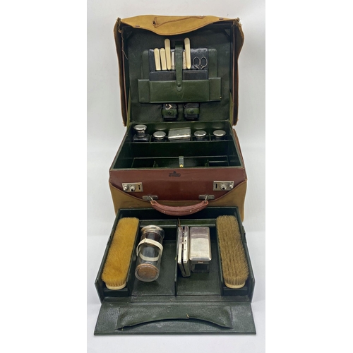 60 - Good quality leather vanity case comprising various silver lidded jars and other tools, 32cm wide
-P... 