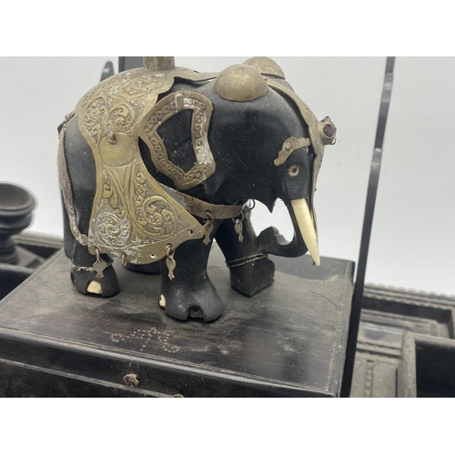 331 - Impressive North-Indian ebony desk standish, mounted by an elephant in ceremonial dress with various... 