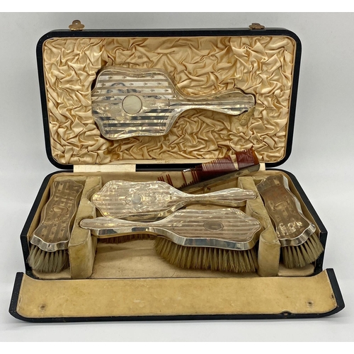 88 - Edwardian silver six piece dressing set, comprising four brushes, comb and hand mirror, with geometr... 