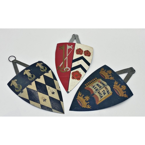 413 - Three hand painted sheet metal wall hanging shields with polychrome decoration, 28cm (3)