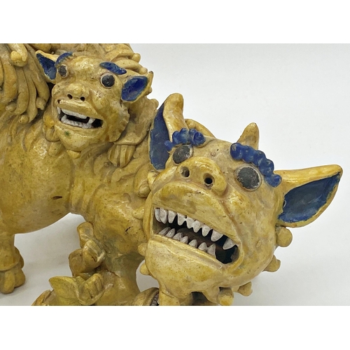 493 - Unusual pair of Chinese pottery Dogs of Fo in famille jaune playing with their young, with blue high... 