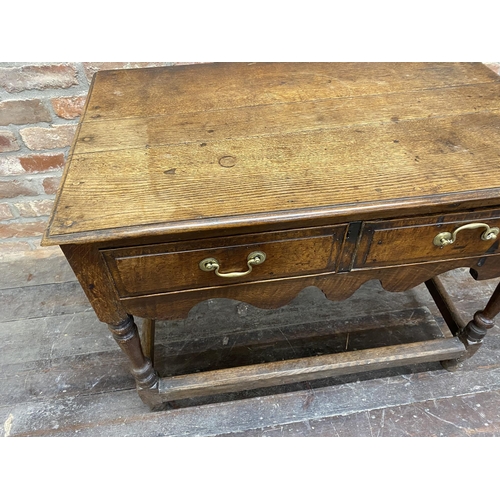 1175 - Georgian oak side table, fitted two drawers with wavy apron and turned legs, supported by a canted s... 