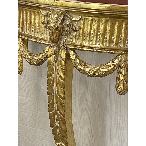 1140 - Marble topped gilt wood demi-lune Adams style console table decorated rams head and swags, 87cm high... 