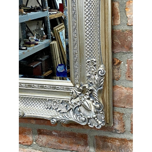 1195 - Decorative silver framed wall mirror with Rococo motifs and bevelled glass plate, 120cm x 86cm