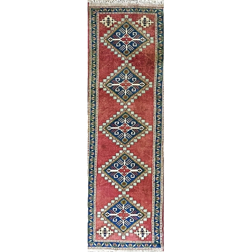 1097 - Turkish runner, five blue medallions, washed red ground, 380 x 90cm