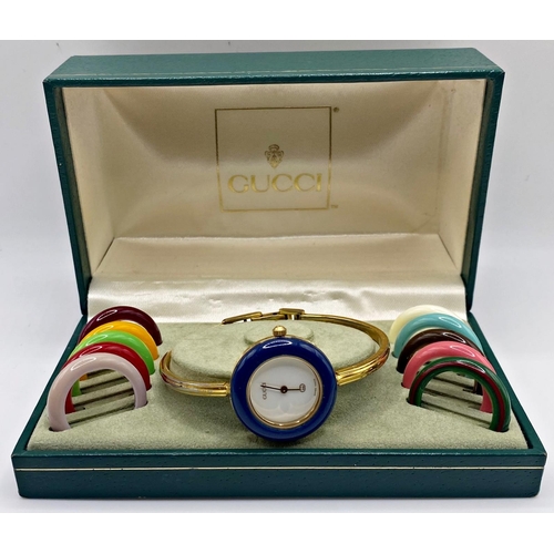 270 - A ladies Gucci fashion watch with interchangeable bezel, the white dial with gilt hands, 25mm case, ... 