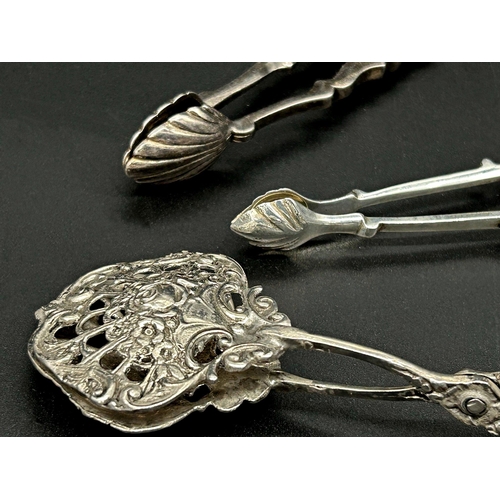 22 - Two pairs of silver sugar nips with a further continental white metal example (3)