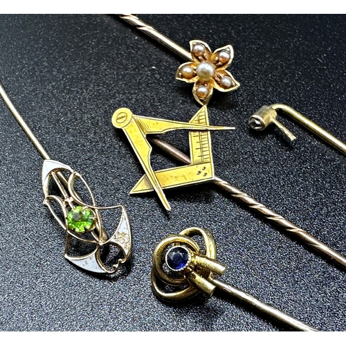 318 - Five gold stick pins to include an Art Nouveau enamel and green stone, diamond, sapphire, seed pearl... 