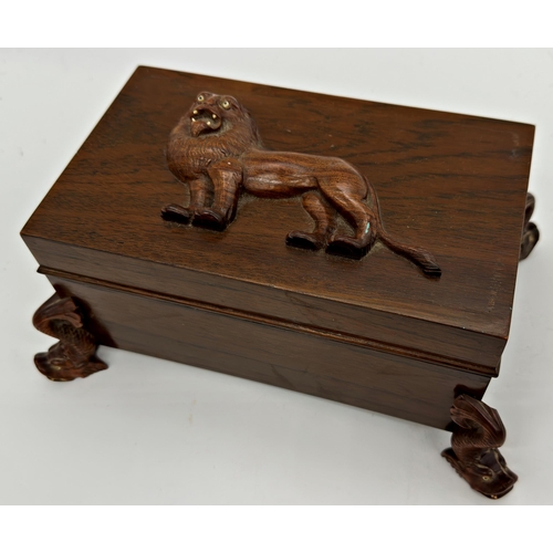 1068 - Early 20th century Indian rosewood jewellery casket, the top carved with a rampant lion upon four ca... 