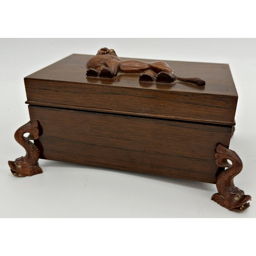 1068 - Early 20th century Indian rosewood jewellery casket, the top carved with a rampant lion upon four ca... 