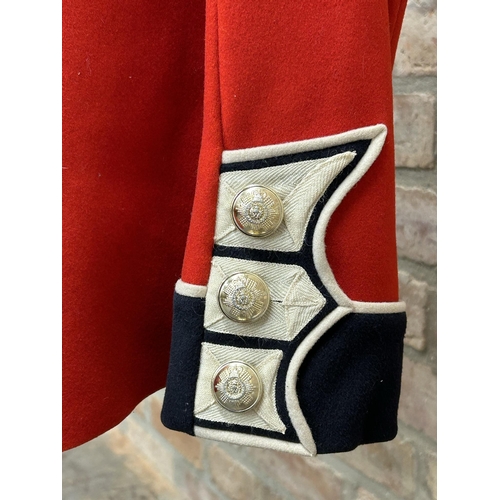 1253 - Vintage Scott's Guard red tunic uniform, with buttons and belt, upon a mannequin stand, 137cm high i... 