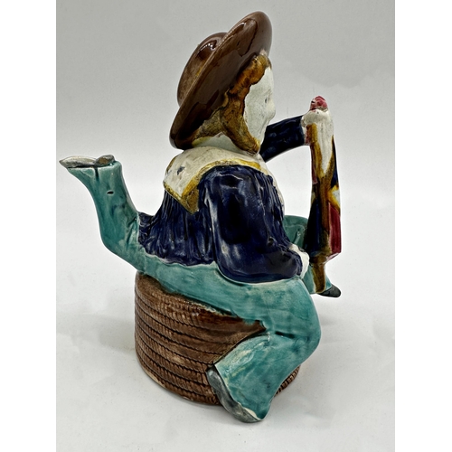 1020 - Aesthetic Movement Majolica Manx novelty tea pot, modelled as a three legged sailor, seated on a coi... 