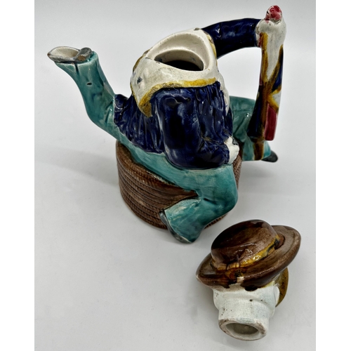 1020 - Aesthetic Movement Majolica Manx novelty tea pot, modelled as a three legged sailor, seated on a coi... 