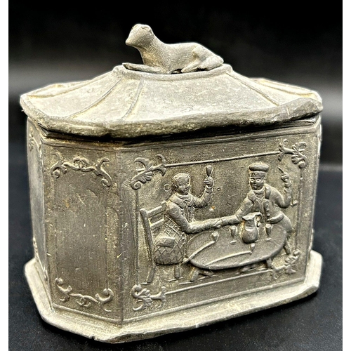 1174 - Georgian lead tea caddy, relief decoration of a tavern scene and recumbent hound to lid, 13cm high