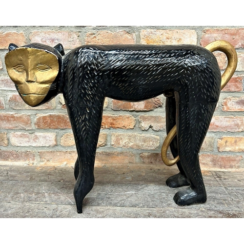 1064 - Large carved wooden sculpture of a monkey, black painted with gilt highlights, 55cm high x 77cm long