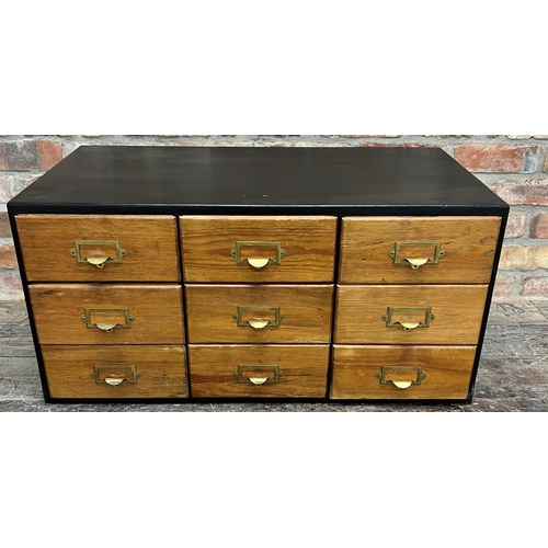 1183 - Vintage Industrial table top bank of nine drawers, with brass fittings in an ebonised case, 43cm hig... 