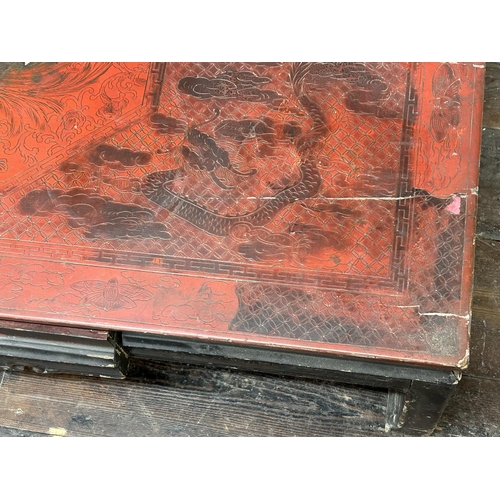 515 - Antique Chinese red lacquered coffee table, decorated with dragons and griffins, 33cm high x 97cm wi... 