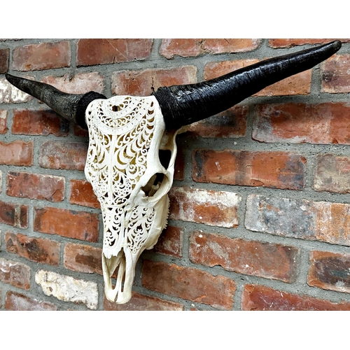 125 - Taxidermy - Bull skull with horns, with filigree type carved decoration, 48cm high x 78cm wide