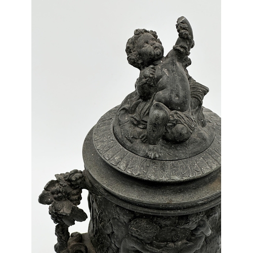 584 - 19th century cast pewter lidded urn decorated in relief with the feast of Bacchus, 32cm high