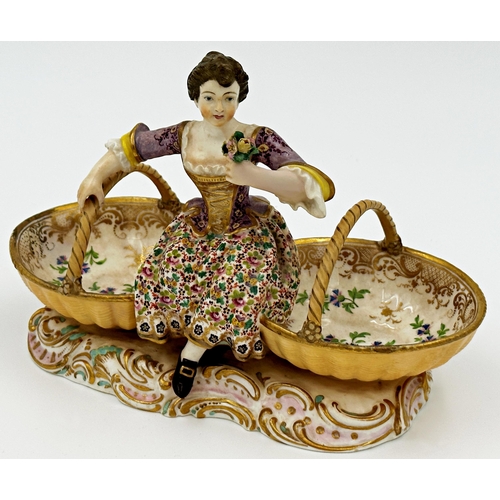 467 - Probably by Derby porcelain twin salt, modelled as a female flower picker flanked by two baskets, wi... 