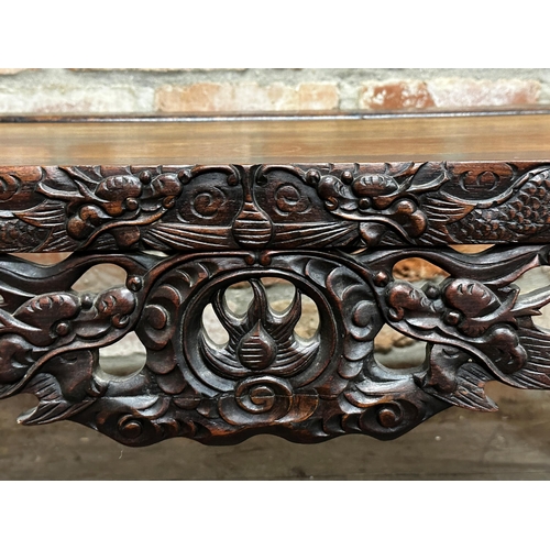 514 - 19th century Chinese hardwood scroll-end low table, well carved with dragons, 41cm high x 100cm long