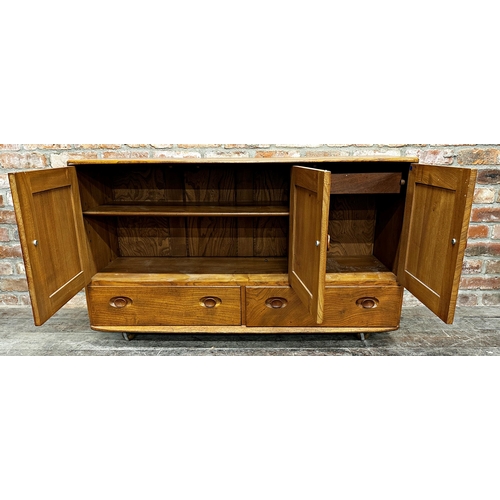 1202 - Ercol light elm sideboard, three cupboard doors over two drawers on casters, 76cm high x 130cm wide