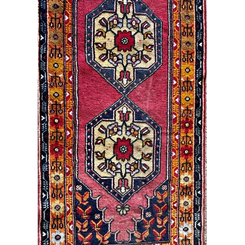 1409 - Good full pile Afghan runner with red motifs on a blue ground, 290 x 110cm