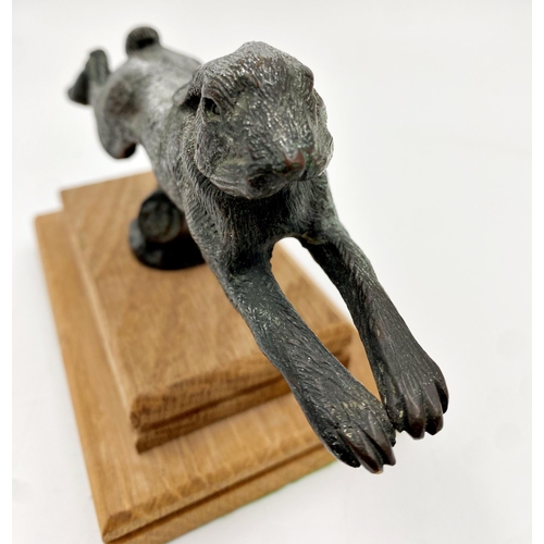 245 - Silvered bronze car mascot in the form of a leaping hare, on stepped oak plinth, 11cm high x 18cm lo... 