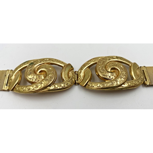 318 - Yellow metal stylised bracelet, with twin pierced scrolled hinged centre, on a watch type strap, mar... 