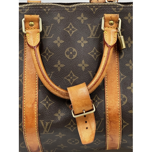 254 - A classic Louis Vuitton Keepall 50 travel bag in brown monogram canvas and leather.
Hardware in gilt... 