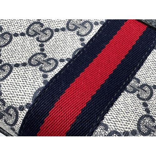 261 - A vintage Gucci monogram GG blue red stripe crossbody bag featuring signature navy Gucci GG print ca... 