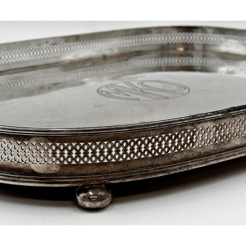 99 - Large silver plate oval tray with pierced gallery sat upon four ball feet with carrying handles. Eng... 