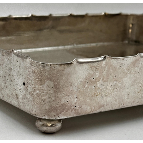 100 - Silver Plated tray with stylised turreted rim, sat upon four ball feet. h7 x l36.3 x w29.5cm