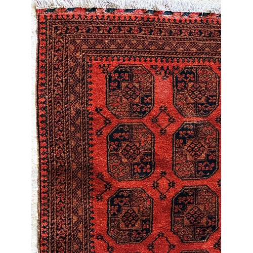 1445 - Persian full pile Bokhara rug, with typical medallion decoration on a deep orange ground, 175 x 120