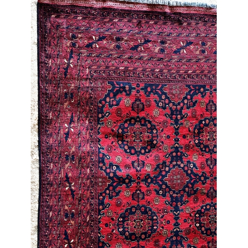 1446 - Good quality Persian fine wool carpet, with geometric medallion decoration on a red ground, 300 x 20... 