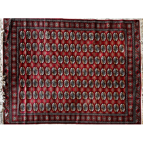 1453 - Large Wilton bokhra wool with typical geometric medallion design upon a red ground, 350cm x 250cm.