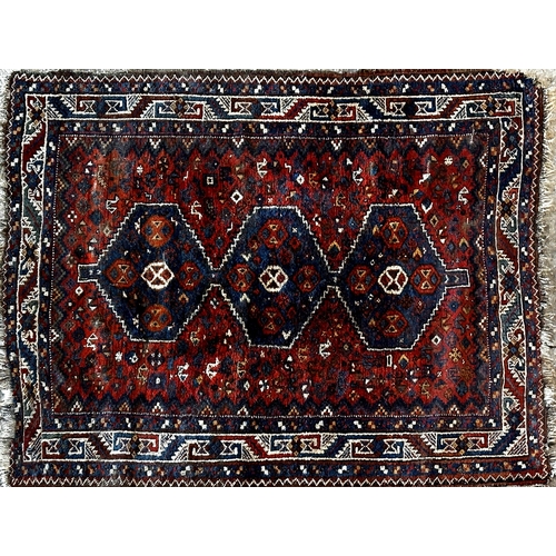 1457 - Antique Afghan rug with three blue medallions and various still lifes upon a rich red ground, 190cm ... 