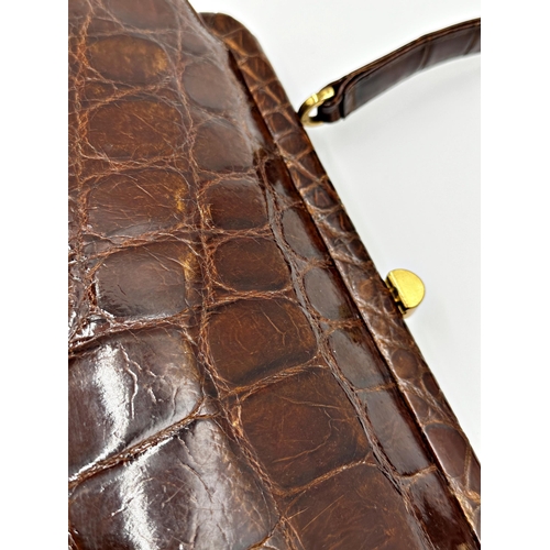 252 - A stunning 1940s brown crocodile skin handbag. Hardware in gilt metal with clasp opening to the top ... 