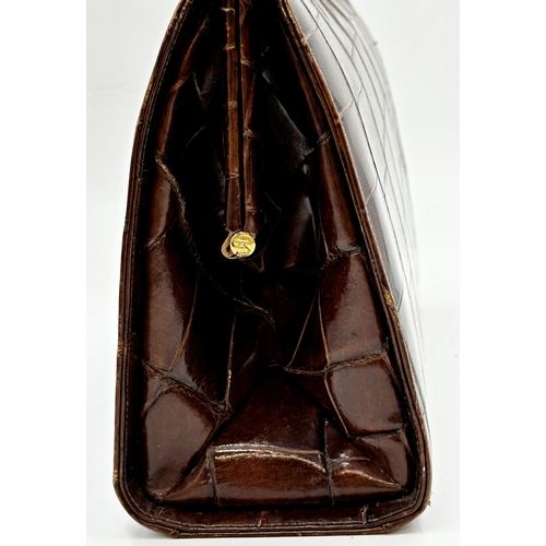 252 - A stunning 1940s brown crocodile skin handbag. Hardware in gilt metal with clasp opening to the top ... 