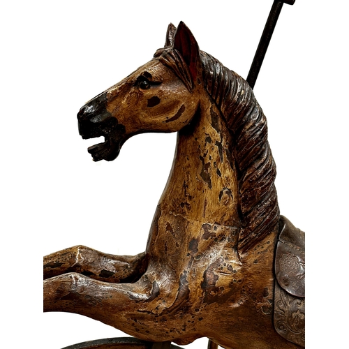 1281 - Carved horse tricycle, with good patina leather saddle and iron wheels and framework, 88cm high.