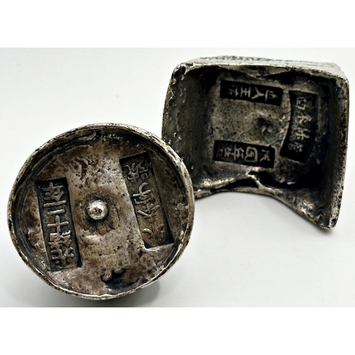 303 - Two Chinese white metal Sycee ingots, one boat shaped the other domed, with typical textured decorat... 