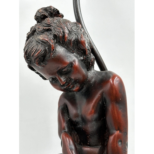 1140 - Resin bronze figural Art Nouveau style table lamp modelled with a seated cherub upon a stepped squar... 