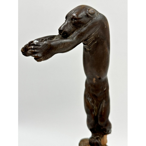 408 - Unusual either Black forest or Japanese carving of a bear with out stretched arms holding a steel ba... 