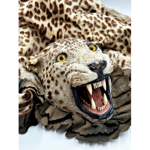 426 - Taxidermy - a leopard skin rug with head, open mouth teeth and tongue, probably by Van Ingen and Van... 