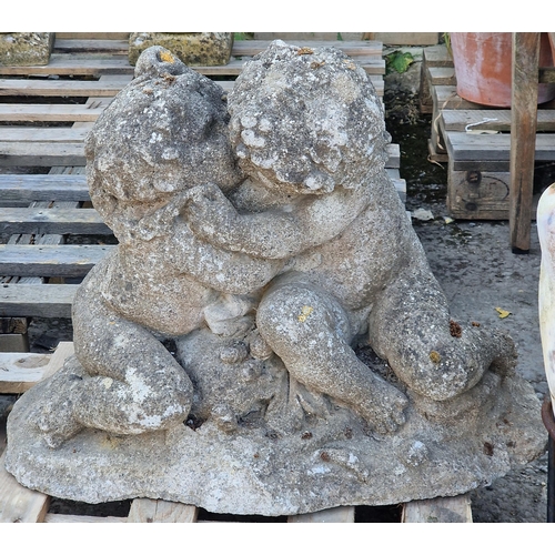 1019 - Antique weathered reconstituted stone garden ornament in the form of cherubs embracing, 50cm high