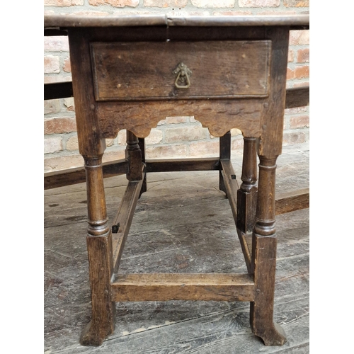 1311 - Early 18th century oak gateleg table with wavy apron fitted with a single drawer united by stretcher... 