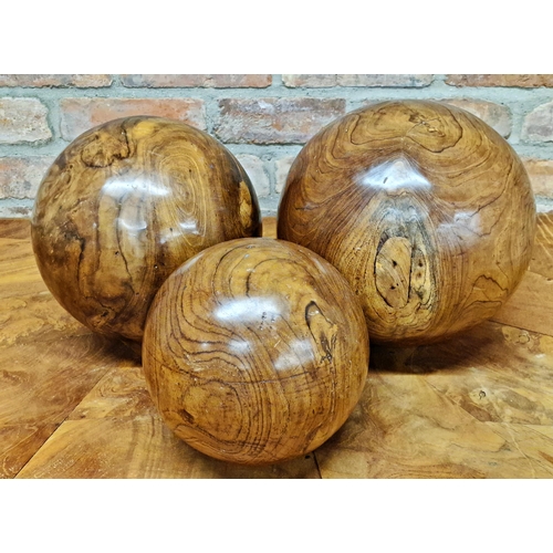 409 - Three large carved walnut balls, the largest 30cm diameter