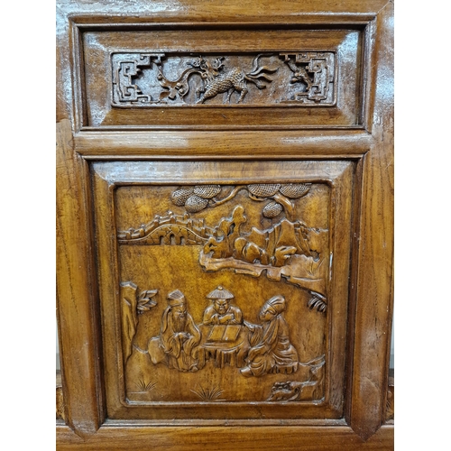 329 - A Chinese possibly elm or hardwood hall bench, with carved panels of birds and dragons, further pier... 